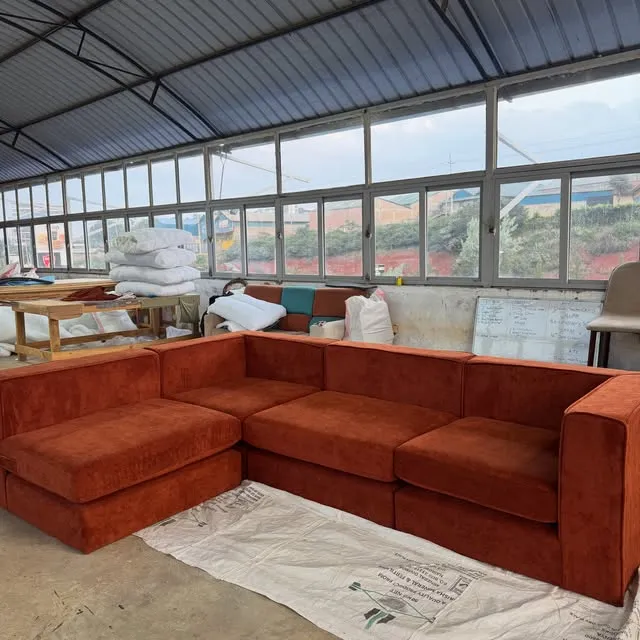 A rust-coloured sectional sofa on the workshop floor.