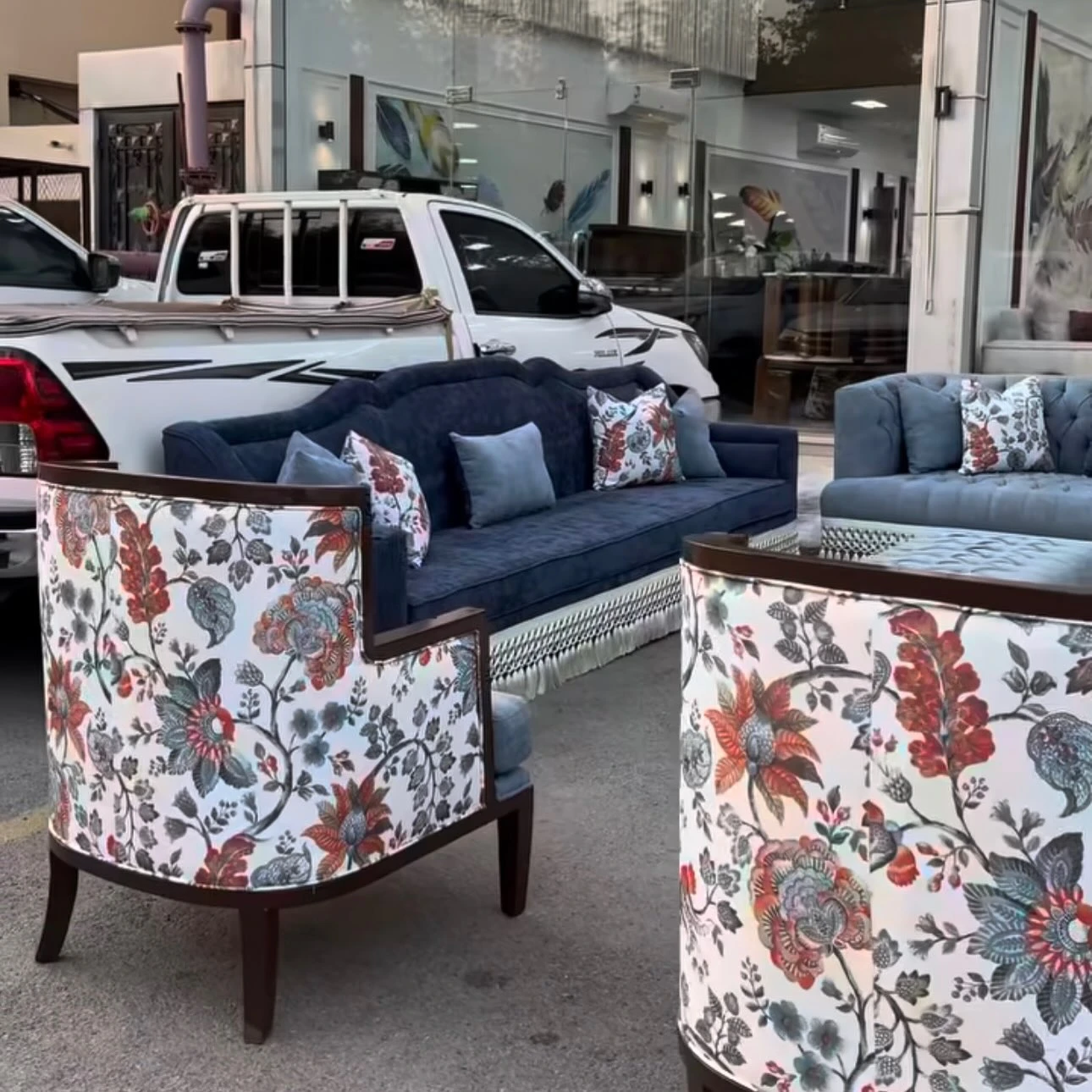 Floral wing chairs and a navy sofa outside the Etana showroom.